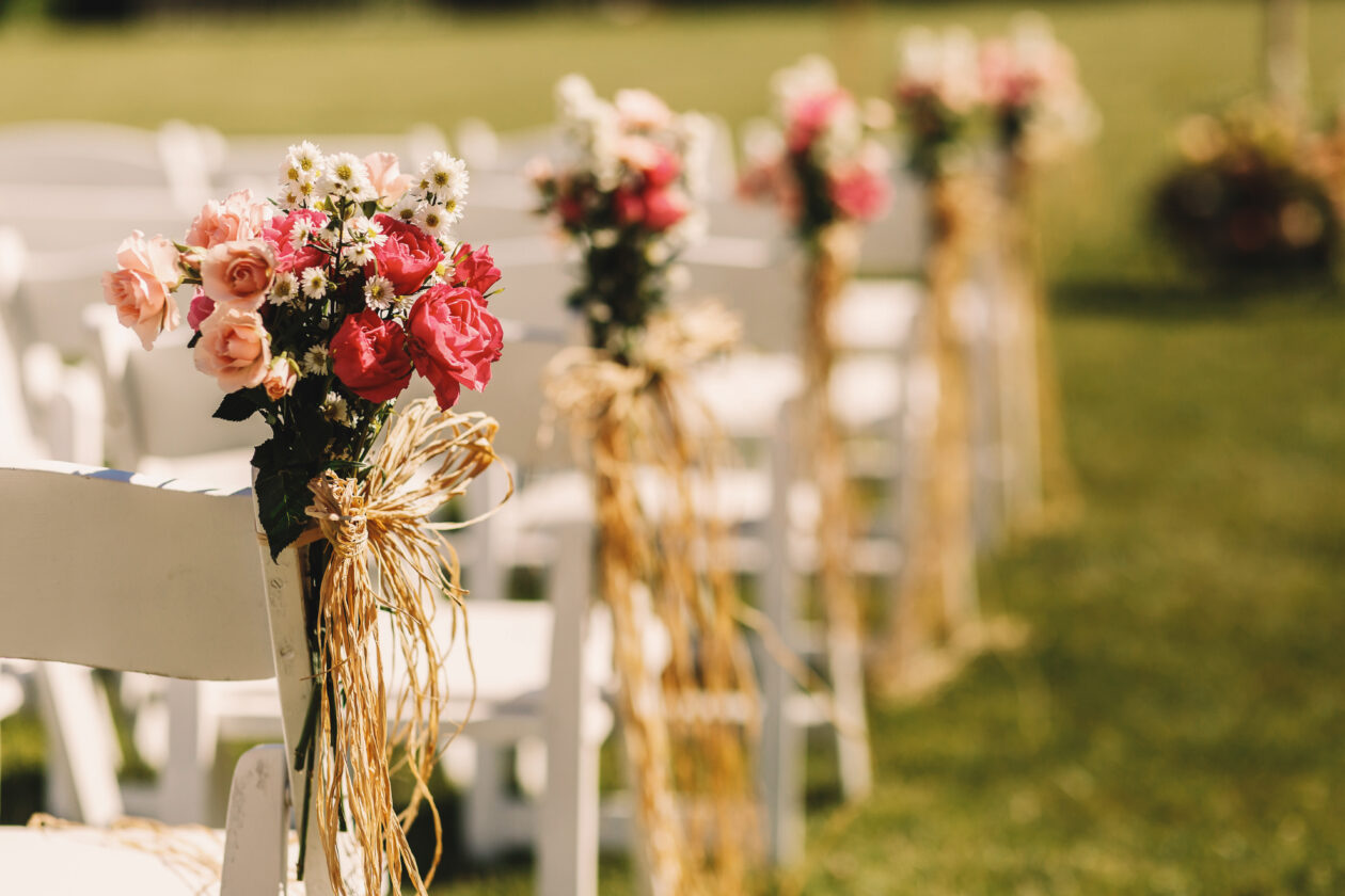 Bows of rope twine pink bouquets to white chairs